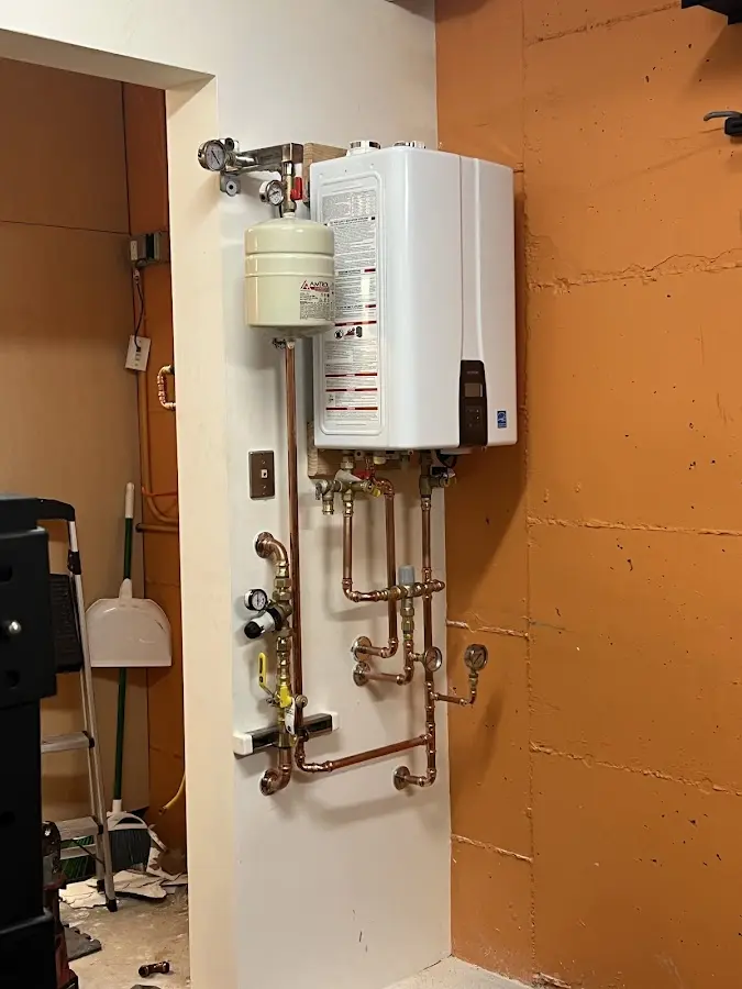 Plumbing technician inspecting water heater connections in Salisbury